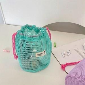 Detail of mint green mesh drawstring pouch with pink cord and white logo label