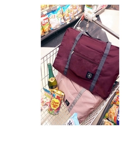 Waterproof foldable travel bags in burgundy and pink colors used in shopping basket