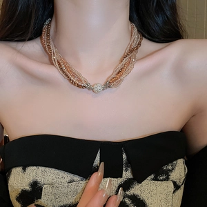 Detailed view of multilayer beaded necklace with sparkling champagne crystal pave ball