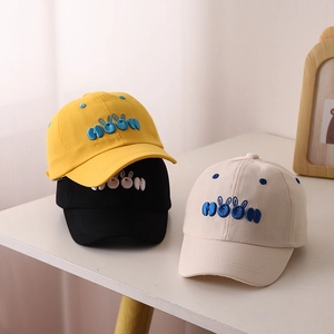 Close-up of children's baseball caps with moon embroidery in yellow, black and beige