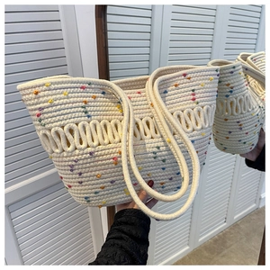 Detail of hand-woven cream tote bag with colorful dots showing side texture and capacity