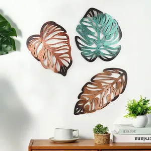 Three-piece metal palm leaf wall decor set in vintage bronze finish on white wall