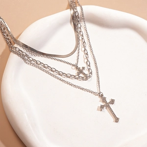 Detail of silver layered necklace with rhinestone-encrusted cross charms on snake chain