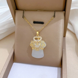 Detail of Ruyi style hollow necklace with white faux jade and diamonds in a jewelry box