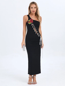 Détails de broderie rose rouge et laçage argenté sur cette robe moulante noire