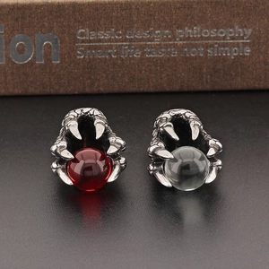 Macro detail of gothic dragon claw pendants holding red and clear crystal beads