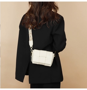 Detailed view of woven leather bag with wide jacquard geometric pattern strap