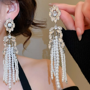 Detailed macro view of crystal flower earrings with long pearl tassels for elegant evening wear