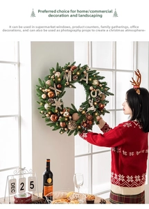 Femme installant une couronne de Noël de 60cm avec pommes de pin et lumières LED au salon