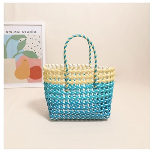 Detail of colorful woven tote bag featuring yellow and blue stripes with durable handles
