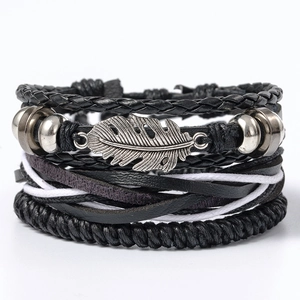 Detail of multi-layer leather bracelet featuring a silver feather charm and woven cords