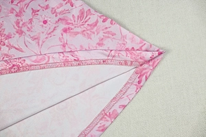 Détail de la robe à fleurs roses montrant les coutures de surjet et la finition du tissu