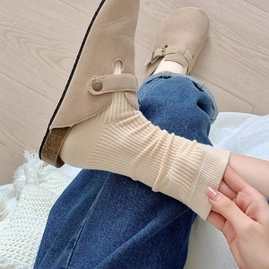 Beige suede mule clogs for women featuring cork soles and classic metal buckle strap