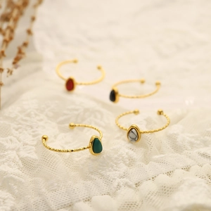 French vintage oval natural stone rings in gold finish on white lace fabric background