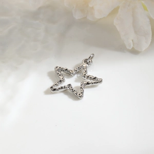 Macro shot of silver star pendant with hollow design and textured finish for DIY jewelry