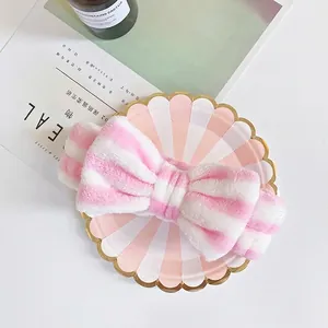Pink and white striped coral fleece headband with a large bow for washing face
