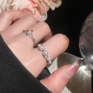Close-up of French vintage open rings with zircon flower and white pearls on hand