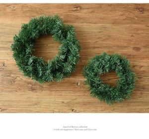 Détail de deux couronnes de Noël artificielles en pin sur fond de bois naturel