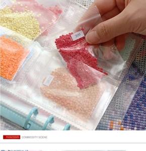 Macro shot of 5D diamond painting drill bags with DMC labels in a binder album