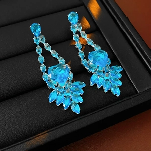 Detail of silver drop earrings featuring heart-shaped blue zircon and marquise stones