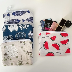 Flat lay of small floral canvas coin purses with ring zippers and storage details