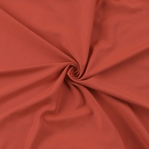 Vista macro detallada de tela plisada rojo óxido con textura fina de sarga y caída suave