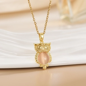 Golden owl pendant necklace with pink cat eye stone and delicate metal carvings