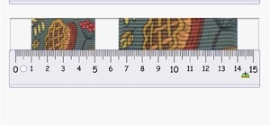 Detail of 2cm autumn themed polyester ribbon with maple leaves and berries showing width