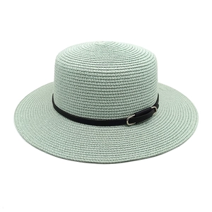 Vue détaillée de la texture de paille tressée vert menthe et du ruban en cuir noir à boucle