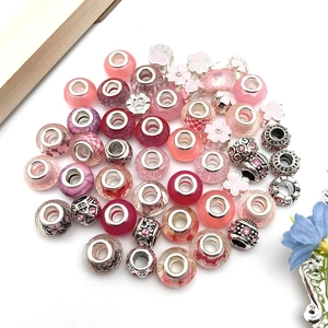 Detailed close-up of pink and silver alloy beads with sparkling rhinestones for DIY bracelets