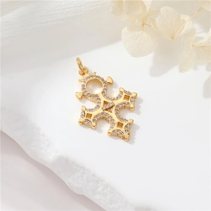 Detailed close-up of a 14K gold plated cross pendant with sparkling zircon inlays