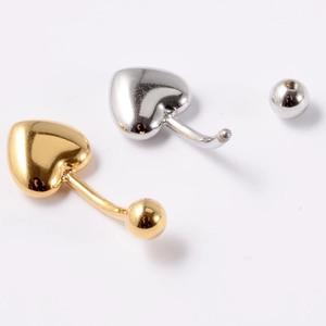 Vue détaillée de piercings de nombril en forme de cœur dorés et argentés à billes