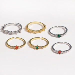 Detail of adjustable rings with red green and white cubic zirconia in gold and silver