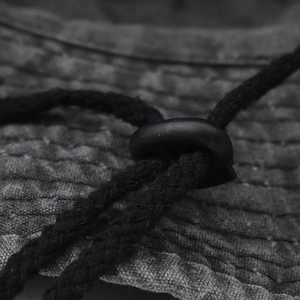 Macro detail of washed cotton sun hat featuring rugged texture and adjustable drawstring