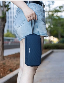 Detail view of the deep blue InfoVault digital organizer bag with a black wrist strap