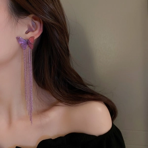 Detail of butterfly long tassel earrings with pink-purple gradient on model