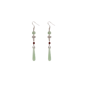 Detailed view of green faux jade teardrop earrings with vintage beaded tassels
