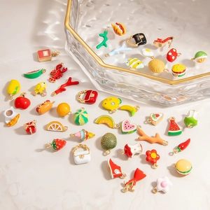 Pendentifs variés en alliage fruits et nourriture dans un plateau pour bijoux artisanaux