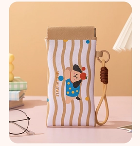 Detail der Brillen-Tasche mit 'MEET SLOWLY' Aufdruck und gewebter Trageschlaufe