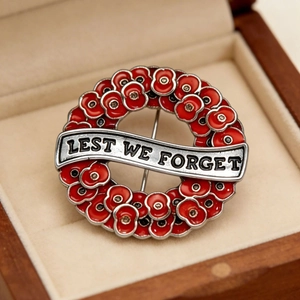 Poppy wreath brooch with Lest We Forget text on silver frame and red enamel finish