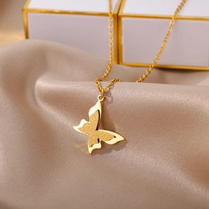 Detailed macro view of gold-plated layered butterfly pendant with matte and polished textures
