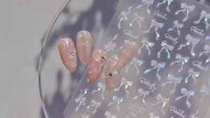 Macro detail of shell glow nail art stickers with bows, flowers and butterfly patterns