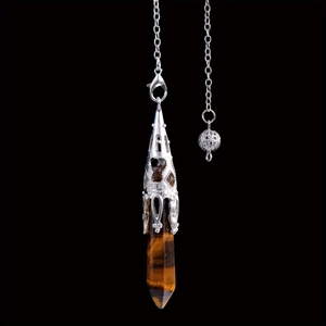 Macro shot of tiger eye stone pendant with silver filigree cap on dark background