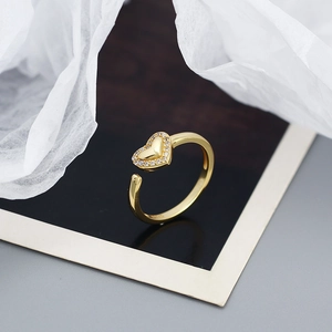 Close-up of heart-shaped open ring in gold with white micro-pave zircon stones