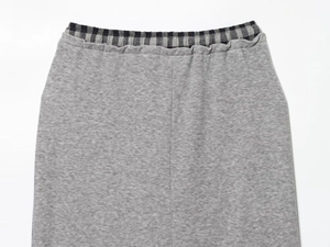 Detail shot of grey knit skirt elastic waistband with contrast black and white plaid lining
