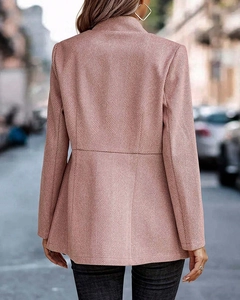 Detail of herringbone texture and tailored back seam on a dusty pink wool blazer