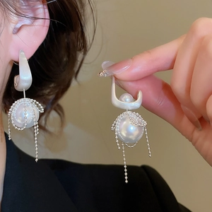 Macro detail of French vintage pearl earrings with silver beaded tassel fringe design