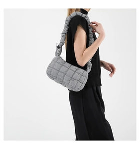 Detailed side view of a grey quilted shoulder bag featuring a stylish ruched cloud strap