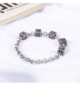 Detail of vintage silver chain bracelet featuring engraved Lucky square charms