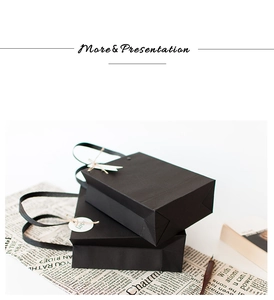 Detail of matte black paper gift bags with Love tags and flat handles on newspaper background